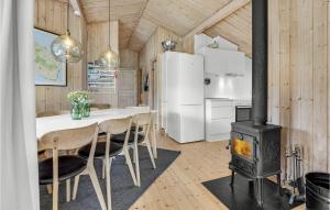 a kitchen and dining room with a wood stove at Blåmejsen in Snogebæk