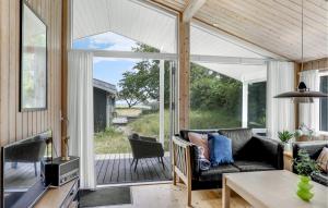 a screened in porch with a couch and a table at Blåmejsen in Snogebæk