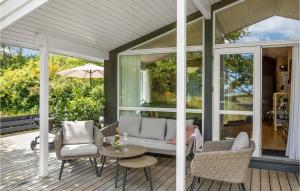 a screened porch with a couch and chairs and a table at Blåmejsen in Snogebæk