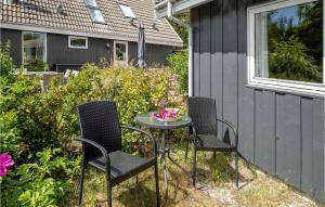 a table and chairs with a bowl of flowers on it at Blåmejsen in Snogebæk