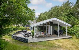 a house with a deck with chairs and tables at Blåmejsen in Snogebæk