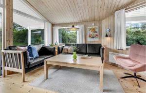 a living room with a couch and a table at Blåmejsen in Snogebæk