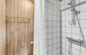 a bathroom with a shower with a wooden wall at Blåmejsen in Snogebæk