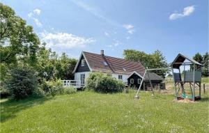 a house in a field with a playground in front of it at Gorgeous Home In Gudhjem With Wifi in Gudhjem