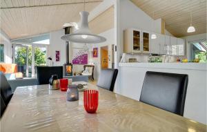 una sala da pranzo con tavolo e una cucina di 3 Bedroom Amazing Home In Vggerlse a Bøtø By
