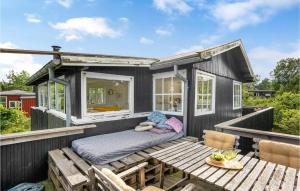 uma pequena casa preta com uma mesa de piquenique em um deck em 3 Bedroom Stunning Home In Grenaa em Grenå mais 7 fotografias
