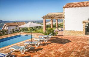 a patio with chairs and an umbrella and a pool at Stunning Home In El Gastor With Wifi in El Gastor +28 photos