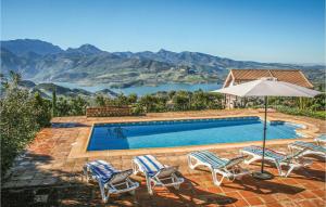 a swimming pool with chairs and an umbrella at Stunning Home In El Gastor With Wifi in El Gastor