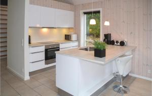 una cucina con mobili bianchi e un piano di lavoro di Three-Bedroom Holiday Home In Blavand a Blåvand Altre 16 foto