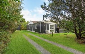 ブラーバンドにあるAmazing Home In Blvand With 4 Bedrooms, Sauna And Wifiの草の庭を前にした黒い家