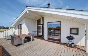 Casa con terraza de madera con mesa y sillas en 3 Bedroom Cozy Home In Sydals, en Skovby