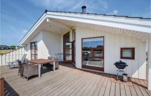 a house with a wooden deck with a table and chairs at Holiday Home Ellemose Sydals Ii in Skovby +17 photos