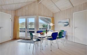 3 Bedroom Awesome Home In Fan في Sønderho: غرفة طعام مع طاولة بيضاء وكراسي زرقاء