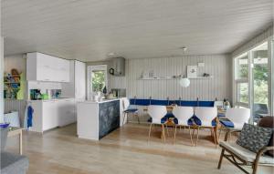 a kitchen with white cabinets and a table and chairs at Lovely Home In Spøttrup in Spottrup