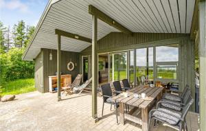 a patio with a wooden table and chairs on it at Amazing Home In Spttrup With House Sea View in Spottrup