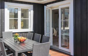 a wooden table with a bowl of fruit on a patio at Gorgeous Home In Ejstrupholm With Wifi in Ejstrup +14 photos