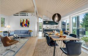 a kitchen and living room with a table and chairs at Three-Bedroom Holiday Home In Vaggerlose in Marielyst