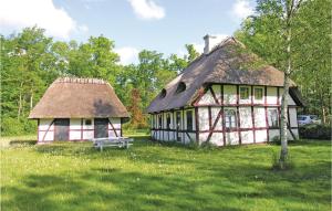 una casa antigua con techo de paja y banco en Beautiful Home In Gudbjerg Sydfyn With Kitchen, en Gudme