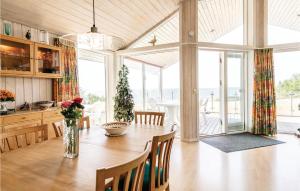een eetkamer met een tafel en een groot raam bij 4 Bedroom Awesome Home In Rnne in Rønne