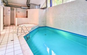 a swimming pool with blue water in a bathroom at Stunning Home In Nex With 5 Bedrooms, Sauna And Wifi in Bedegård