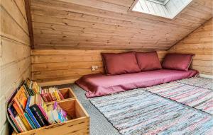 a small bed in a wooden room with books at Stunning Home In Nex With 5 Bedrooms, Sauna And Wifi in Bedegård