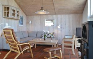 a living room with a couch and a table and chairs at 3 Bedroom Cozy Home In Hvide Sande in Havrvig