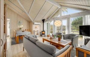 a living room with couches and a table and a tv at Stunning Home In Assens With Sauna in Assens