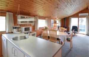 cocina y comedor con mesa y sillas en Awesome Home In Hvide Sande With Kitchen, en Nørre Lyngvig
