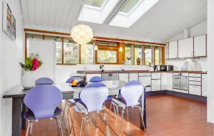 uma cozinha com uma mesa com cadeiras roxas em 5 Bedroom Stunning Home In Gilleleje em Gilleleje