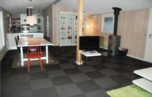 una cucina e un soggiorno con un tavolo e una televisione di Holiday Home Romo With A Fireplace 333 a Rømø Kirkeby