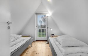 ゲッサーにあるStunning Home In Gedser With Kitchenの白い部屋で、ベッド2台、窓が備わります。