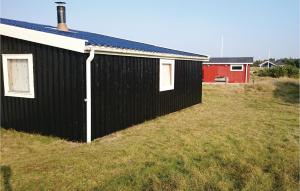 een zwart gebouw bovenop een grasveld bij Gorgeous Home In Fan With Kitchen in Fanø