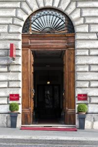 wejście do budynku z drewnianymi drzwiami w obiekcie Vibe Nazionale w Rzymie