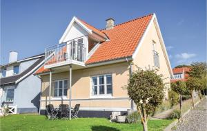 a house with an orange roof and chairs in the yard at One-Bedroom Holiday Home In Tranekar in Lohals +27 photos
