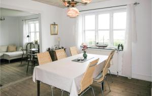 a dining room with a white table and chairs at One-Bedroom Holiday Home In Tranekar in Lohals