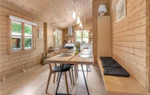 Vester SømarkenにあるNice Home In Aakirkeby With 3 Bedrooms, Sauna And Wifiのダイニングルーム(木製の壁、テーブル、椅子付)