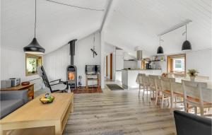 3 Bedroom Pet Friendly Home In Toftlund في Arrild: غرفة معيشة ومطبخ مع طاولة وكراسي