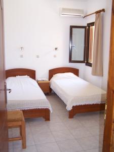 A bed or beds in a room at Aptera Hotel