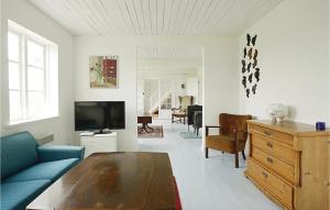 グドイェムにあるAmazing Home In Gudhjem With 4 Bedrooms And Wifiのリビングルーム(青いソファ、テレビ付)