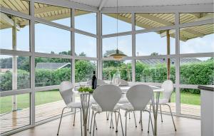 a dining room with a white table and white chairs at Holiday Home Brombærvænget Hejls Ix in Hejls