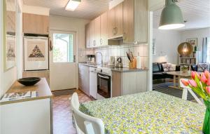 eine Küche und ein Esszimmer mit einem Tisch und einem Esszimmer in der Unterkunft 3 Bedroom Amazing Home In Nexø in Neksø