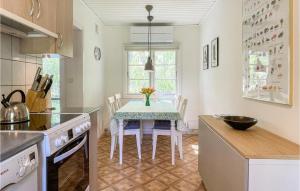 eine Küche mit einem Tisch mit einer Vase mit Blumen darauf in der Unterkunft 3 Bedroom Amazing Home In Nexø in Neksø