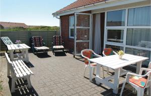 a patio with white tables and chairs and a table at Holiday Home Laust Diges Vej Hvide Sande Ix in Havrvig +15 photos