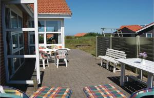 a patio with a table and chairs and a bench at Gorgeous Home In Hvide Sande With Ethernet Internet in Havrvig
