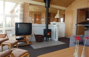 HavrvigにあるBeautiful Home In Hvide Sande With 4 Bedrooms, Sauna And Internetのリビングルーム(暖炉、テレビ付)