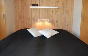 HavrvigにあるBeautiful Home In Hvide Sande With 4 Bedrooms, Sauna And Internetのベッド1台(上に枕2つ付)