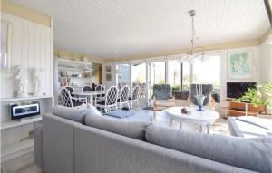 een woonkamer met een bank en een tafel bij 3 Bedroom Gorgeous Home In Juelsminde in Sønderby