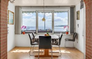 comedor con mesa y sillas y ventana grande en Lovely Home In Rdekro With Kitchen, en Diernæs