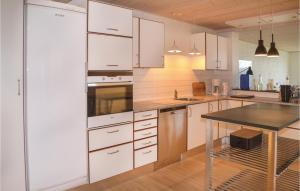 a kitchen with white cabinets and a table in it at Nice Home In Nrre Nebel With Wifi in Nørre Nebel