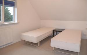 a room with two beds and a table and a window at Nice Home In Nrre Nebel With Wifi in Nørre Nebel